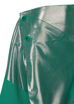 Close-up of NO.17 FOIL by 132 5. ISSEY MIYAKE, showing shiny metallic silver and matte green fabric panels with two green buttons at the waistband. The modern, asymmetrical design uses innovative folds for a three-dimensional silhouette.