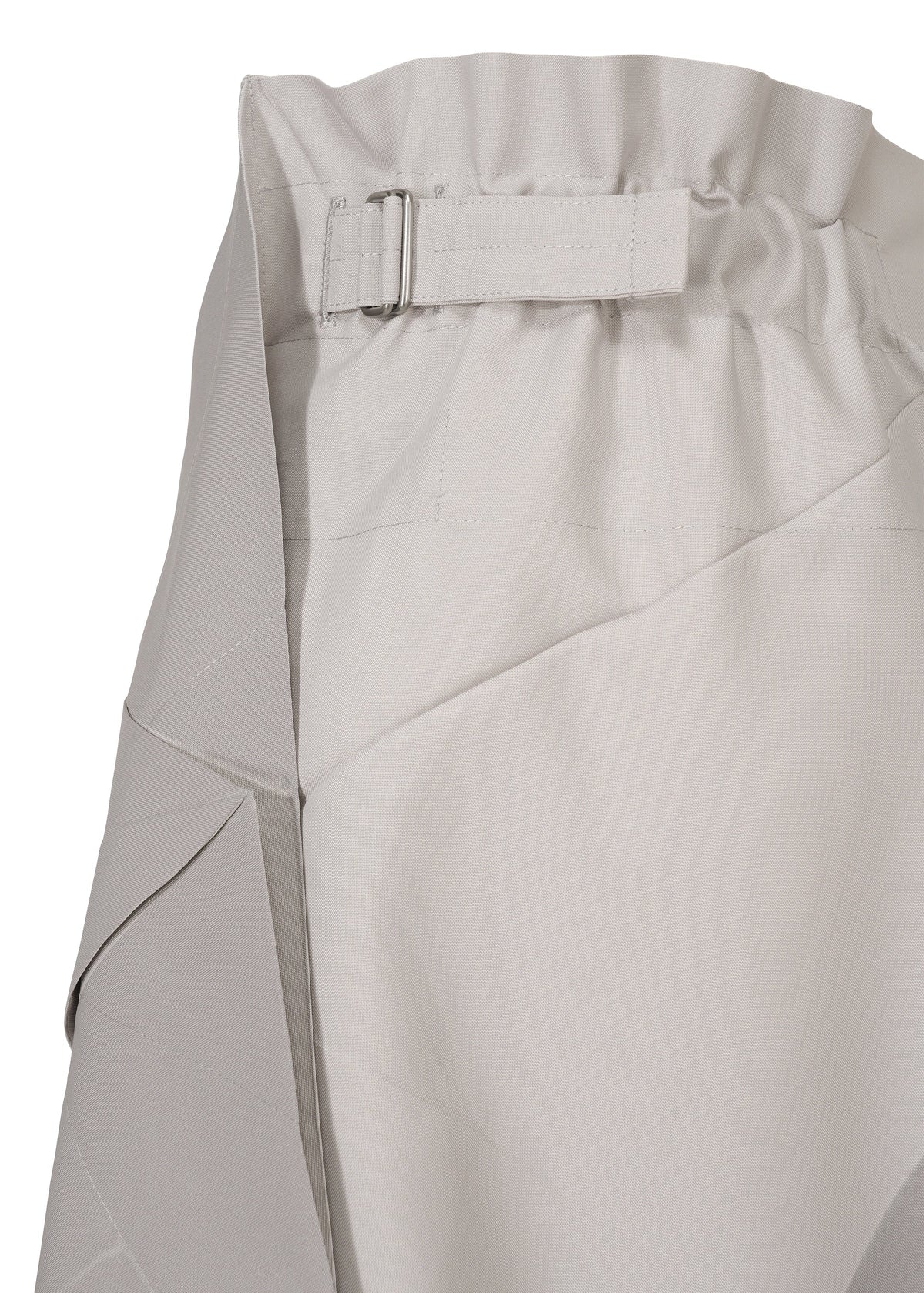 Close-up of NO.17 PRINT skirt by 132 5. ISSEY MIYAKE in light gray, showing a gathered, elastic waistband with fabric strap and rectangular buckle. The smooth, slightly textured fabric features visible seams and folds. view 4 of 11