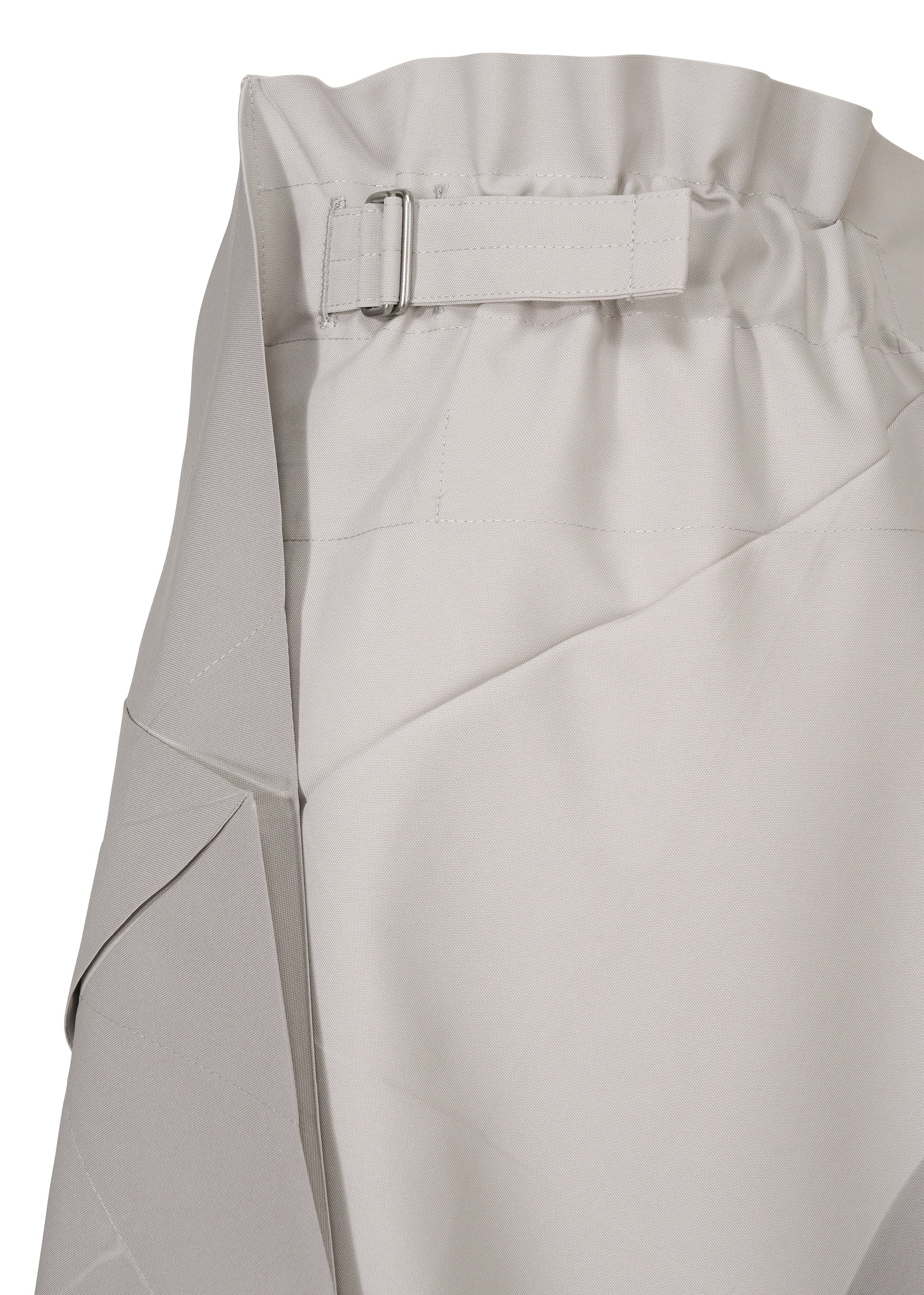 Zoomed view Close-up of NO.17 PRINT skirt by 132 5. ISSEY MIYAKE in light gray, showing a gathered, elastic waistband with fabric strap and rectangular buckle. The smooth, slightly textured fabric features visible seams and folds.