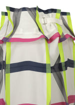 Close-up of the NO.6 TRANSLUCENT sheer skirt by 132 5. ISSEY MIYAKE, featuring a bold neon yellow, pink, white, and dark blue plaid pattern with a silver buckle detail and elegant folds near the top edge.