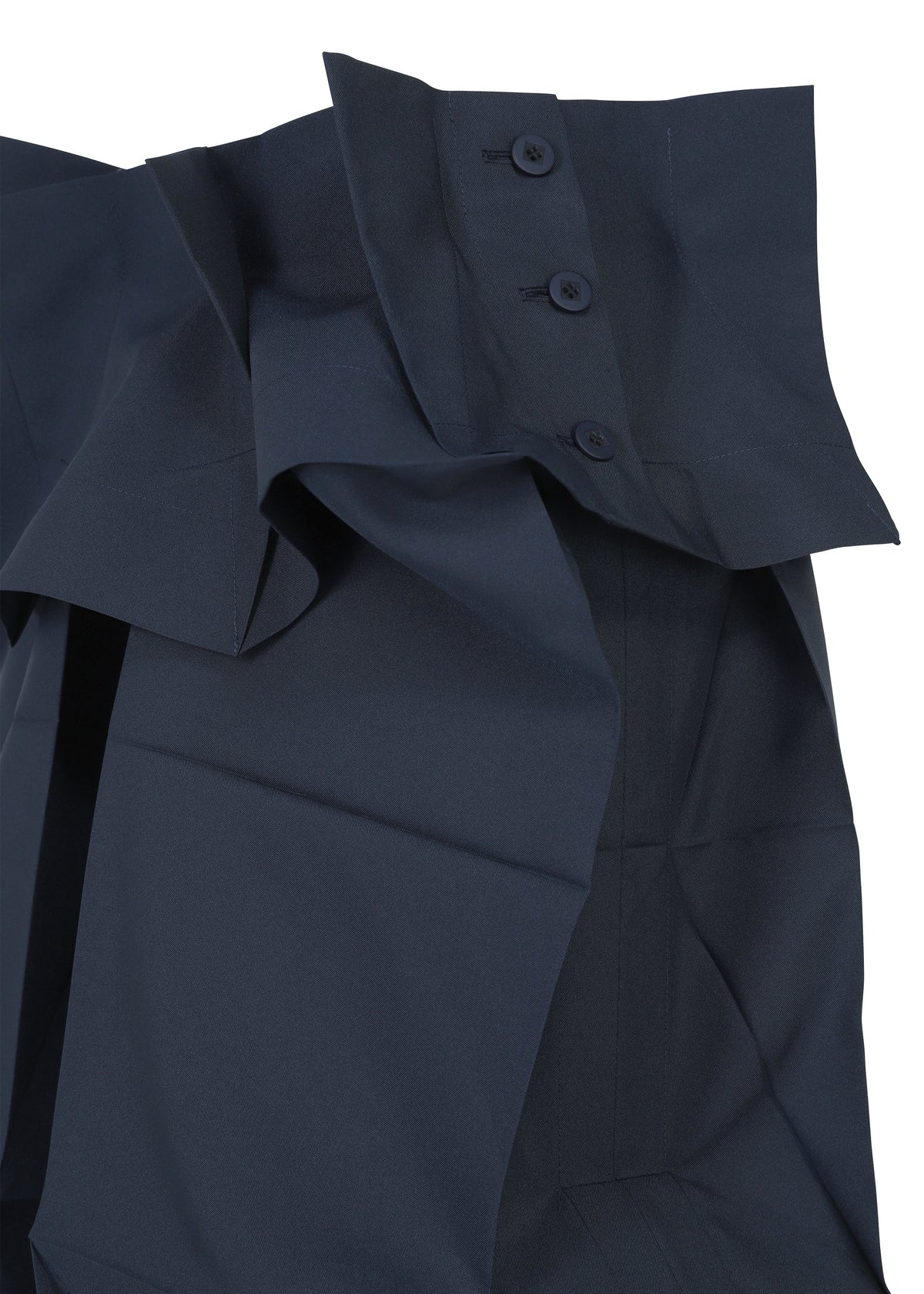 Close-up of the NO.6 SOLID by 132 5. ISSEY MIYAKE in dark blue, showcasing a structured, layered design with three dark buttons on a wide, folded collar and smooth, slightly shiny fabric emphasizing its unique three-dimensional form. view 3 of 11