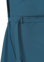 A close-up of the FACET SOLID by 132 5. ISSEY MIYAKE, shown in teal blue. The plant-derived polyester garment features a fabric belt with a rectangular metal buckle, cinched at the waist, and displays smooth texture with subtle seams and pleats.