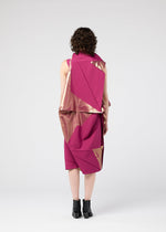 A person with curly hair, seen from behind, wears the 132 5. ISSEY MIYAKE NO.17 FOIL dress in magenta and gold, featuring angular folds and a three-dimensional silhouette, paired with black ankle boots against a plain light gray background.