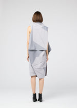 A person with short brown hair stands facing away, wearing the gray NO.17 PRINT dress by 132 5. ISSEY MIYAKE with angular folds and black ankle boots against a plain white background.