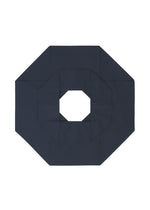 A geometric, dark-colored paper shape like an octagon with a square hole in the center, shown on white, recalls the three-dimensional style typical of 132 5. ISSEY MIYAKE’s NO.6 SOLID design.