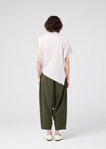 Seen from behind, a person with short curly hair wears the 132 5. ISSEY MIYAKE RADIAL FOLD SHIRT, loose olive green pants, and white flat shoes against a plain light gray background.