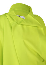 A close-up of the FLAT TUCK T by 132 5. ISSEY MIYAKE, a neon yellow-green collared top with a modern, structured design and smooth fabric. A partially visible white label is sewn inside the collar.