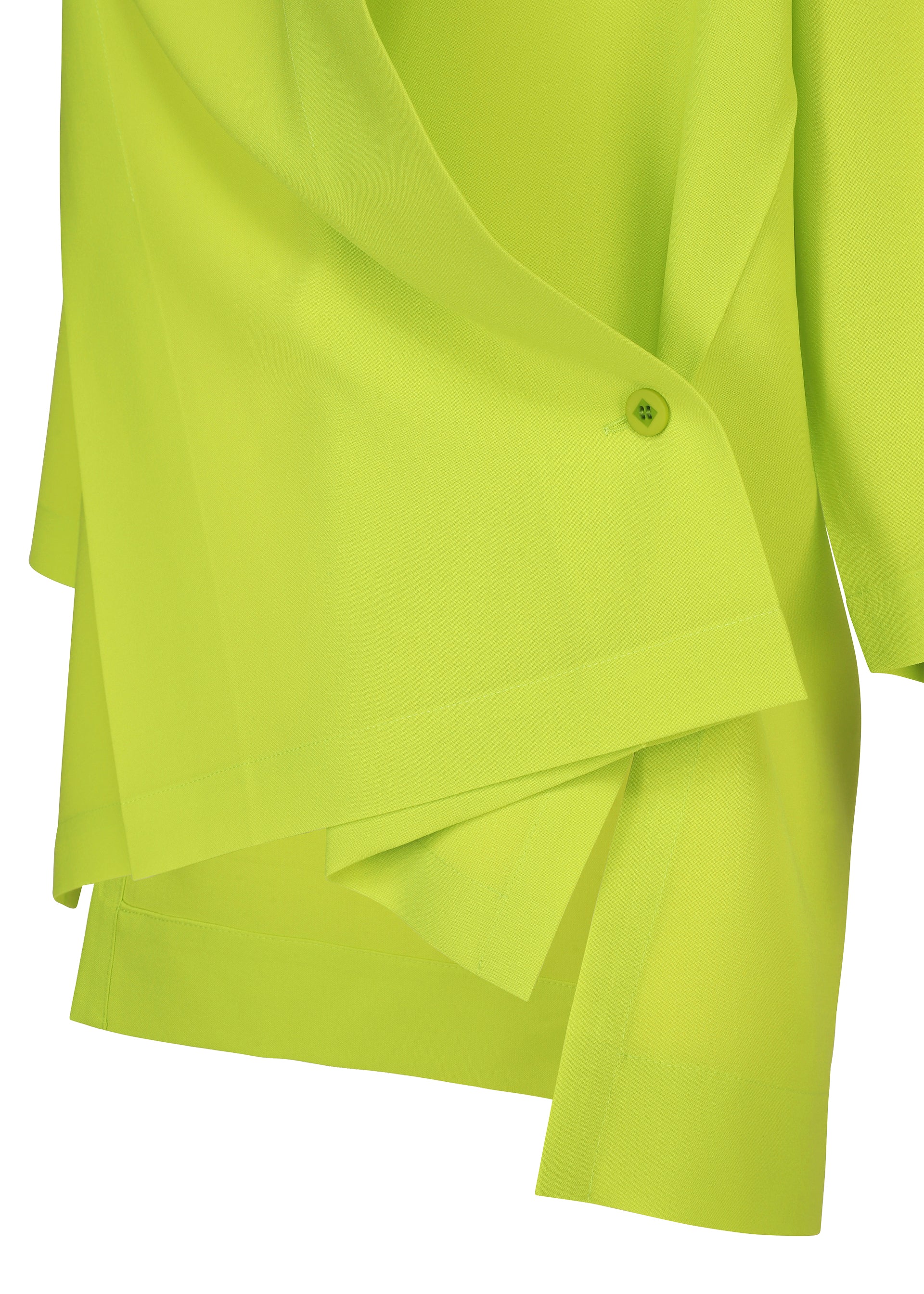 Zoomed view Close-up of the FLAT TUCK T by 132 5. ISSEY MIYAKE in bright lime green, featuring layered smooth lightweight fabric, an asymmetrical hem, and a small button detail.