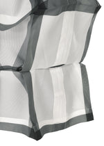 Close-up of NO.6 TRANSLUCENT by 132 5. ISSEY MIYAKE: sheer fabric with wide dark gray stripes, gathered and layered for a soft, textured look. The folds enhance translucency, gently diffusing light through the material.