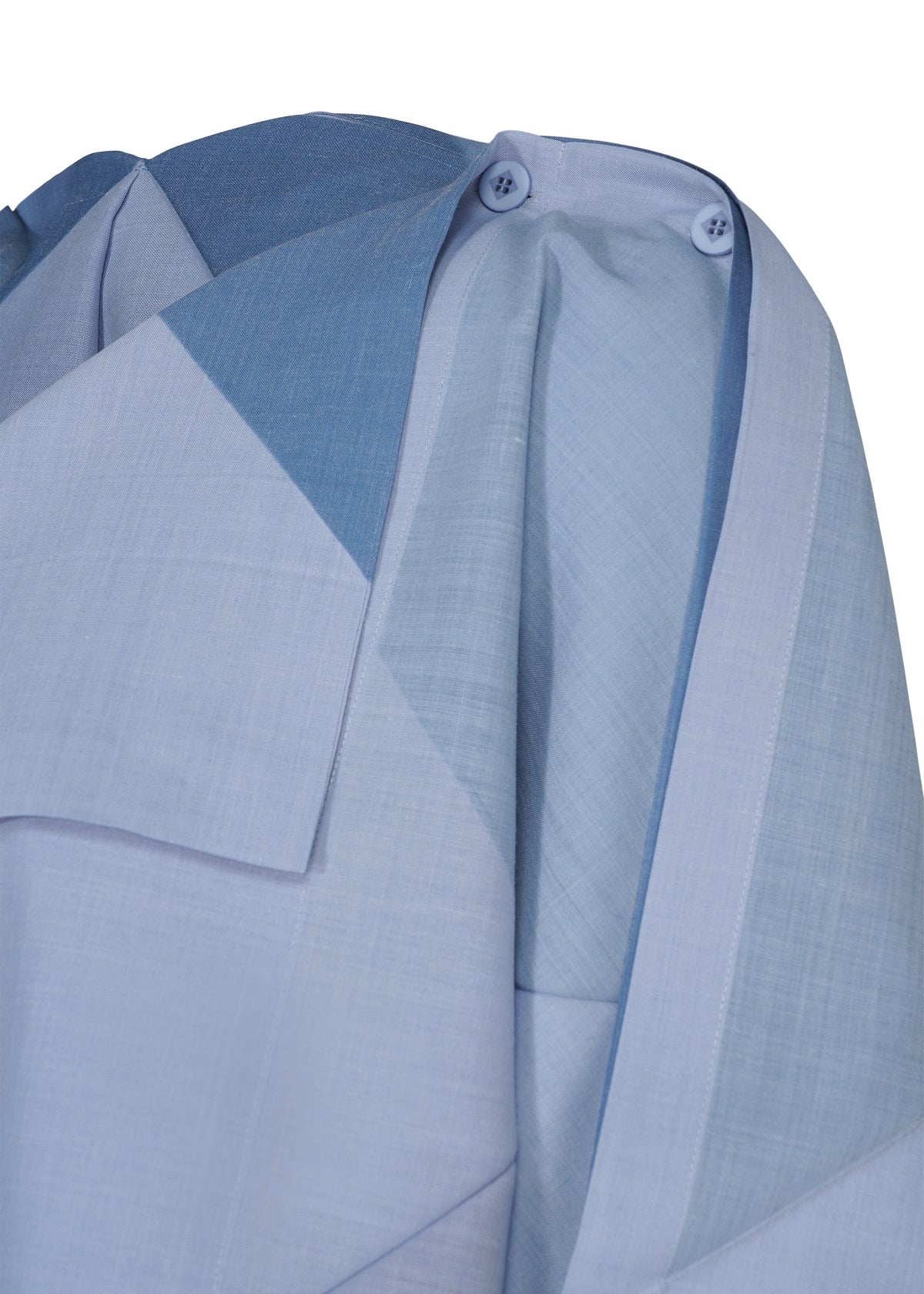 Close-up of the FOLD RAMIE PRINT shirt by 132 5. ISSEY MIYAKE, showcasing a light blue geometric print, overlapping fabric layers, shoulder pleats, and two blue shoulder buttons. The unique design pops against a crisp white background. view 4 of 10