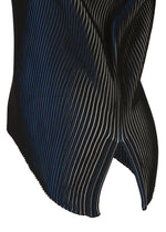 Close-up of FACET KNIT by 132 5. ISSEY MIYAKE: pleated black fabric with thin, diagonal blue and white stripes, wavy texture, curved notched edge, and striking pattern depth from a unique knitting structure.