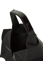 Close-up of the No.1-BG tote by 132 5. ISSEY MIYAKE: black fabric, sturdy leather handles, fine stitching, and a peek inside, all shown against a white background.