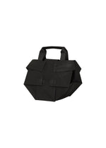 The 132 5. STANDARD BAG by 132 5. ISSEY MIYAKE is a black geometric handbag featuring two large front pockets and a short handle, crafted from recycled polyester, shown against a white background. - BLACK×LUSTER (no.18)