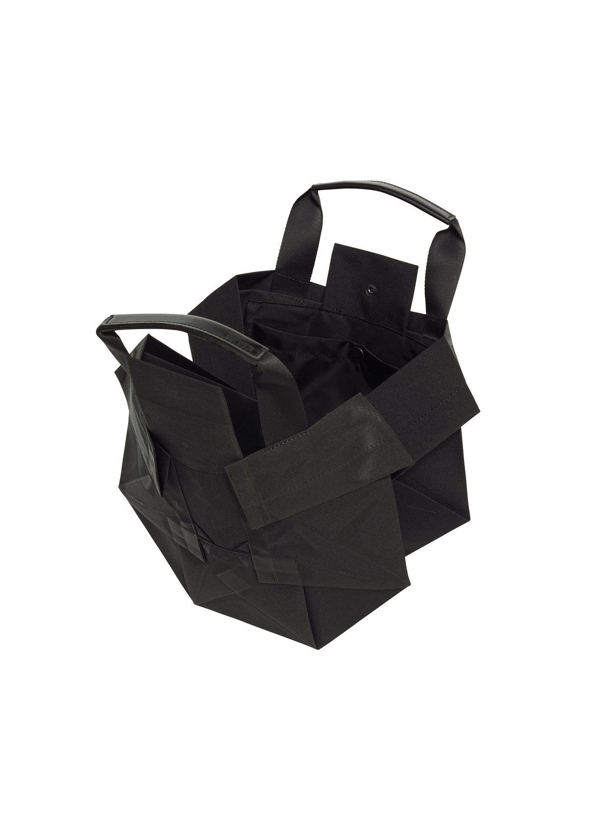 A black, geometric-shaped 132 5. STANDARD BAG by 132 5. ISSEY MIYAKE, featuring a foldable design with short handles and multiple exterior pockets, is displayed on a white background. view 5 of 6
