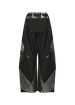 The F-BT wide-leg black folding pants by 132 5. ISSEY MIYAKE feature a geometric design and shiny metallic silver foil on the waistband and lower legs, shown against a plain white background.