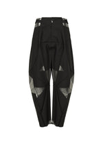 The F-BT pants by 132 5. ISSEY MIYAKE are black harem-style trousers made from recycled polyester, featuring geometric silver foil accents, angular paneling, belt loops, button closure, and a loose fit tapered at the ankles.