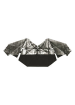 The F-BT by 132 5. ISSEY MIYAKE is an origami sculpture with angular wings and a geometric body, crafted from black and silver foil processing paper, resembling a stylized bat or bird against a white background.