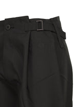 Close-up of F-BT black recycled polyester pants by 132 5. ISSEY MIYAKE, featuring a side adjuster strap with metal buckle, button closure at the waistband, and structured, slightly textured fabric.