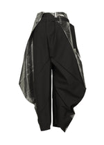The F-BT pants by 132 5. ISSEY MIYAKE feature a high-waisted, asymmetric design crafted from black recycled polyester with wide angular drapes, metallic silver panels, foil processing, and a sculptural, layered silhouette.