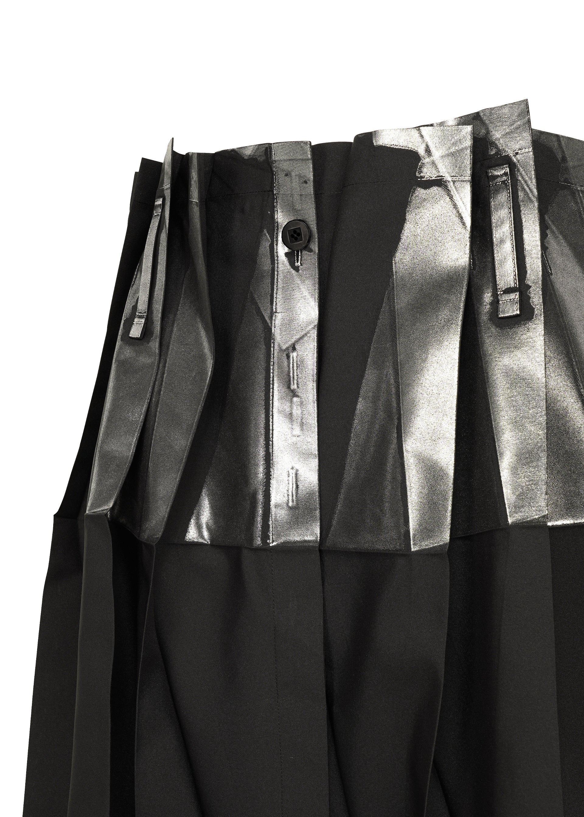 Zoomed view Close-up of No.3-1 pants by 132 5. ISSEY MIYAKE in black recycled polyester, with wide pleated waistband, metallic silver foil detailing on the pleats, and a visible black center button.