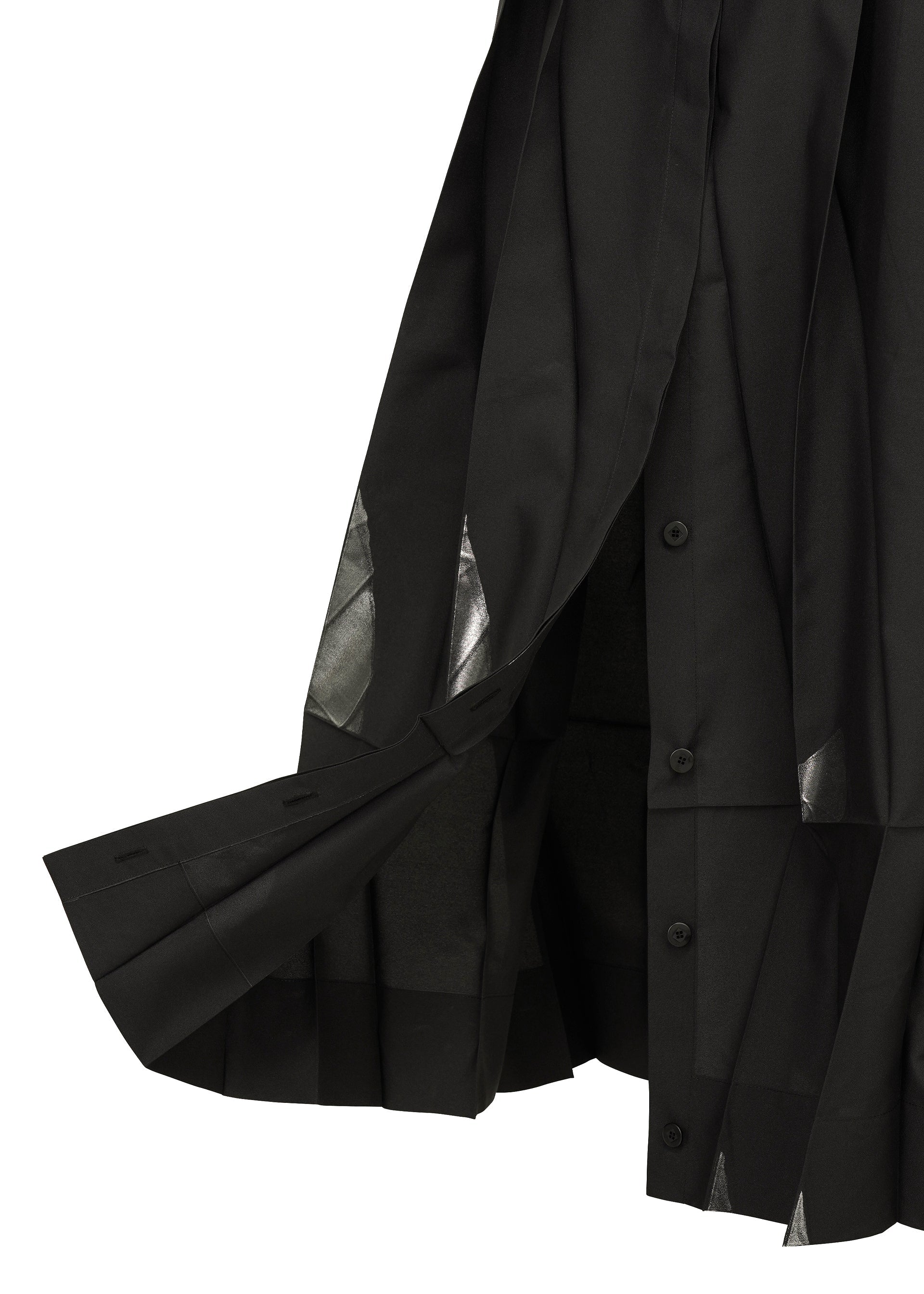 Zoomed view A close-up of the No.3-1 by 132 5. ISSEY MIYAKE, featuring a black pleated skirt with button detailing, sheer triangular cut-outs at the hem, layered fabric, and hints of a convertible skirt-pants design.