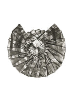 No.3-1 by 132 5. ISSEY MIYAKE features a fan-shaped geometric array of overlapping metallic rectangle strips, resembling foil detail pants, spiraling out on a white background.