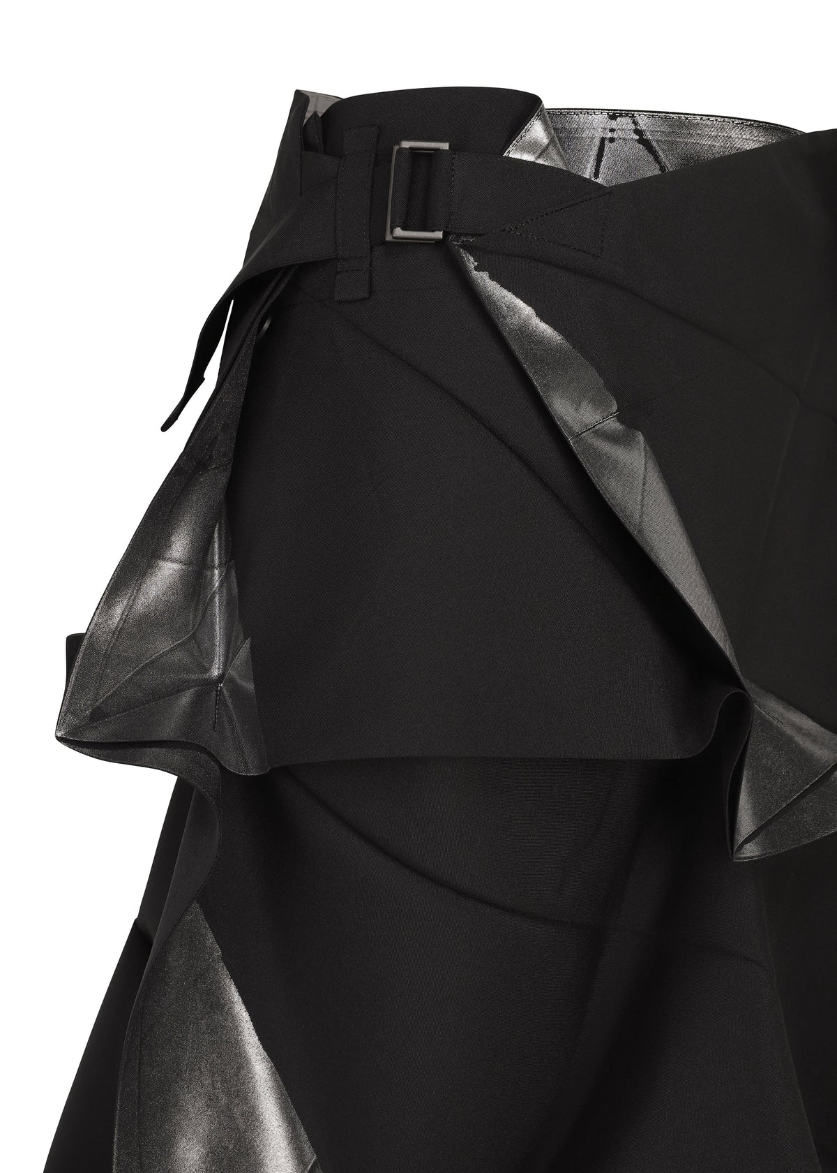 A close-up of the No.1-2 skirt by 132 5. ISSEY MIYAKE showcases its black foil fabric with a silver metallic sheen, featuring layered, angular panels and a black belt with a rectangular buckle. Expertly crafted from recycled polyester, this piece presents an eye-catching flared silhouette that elevates any modern wardrobe. view 4 of 10