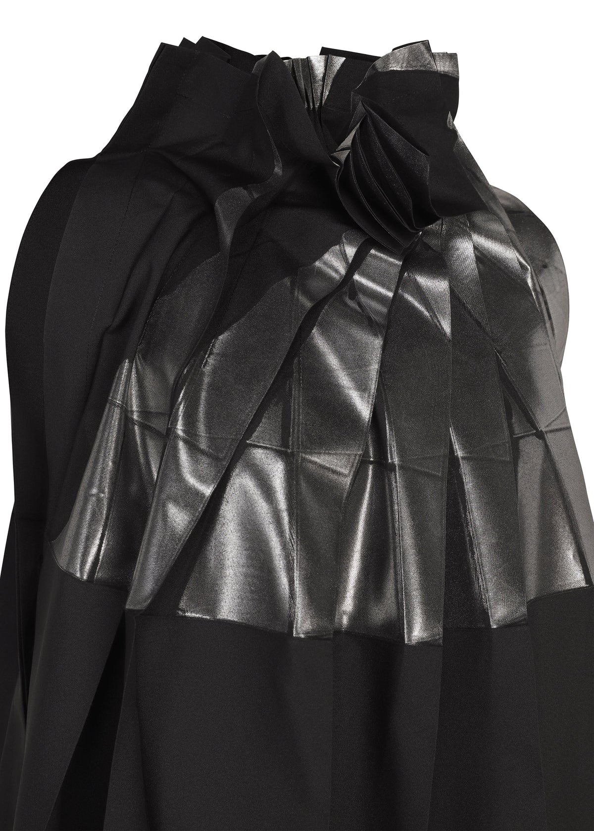 A close-up of No.3-2 by 132 5. ISSEY MIYAKE, a black recycled polyester dress featuring shiny, metallic-textured pleats and overlapping folds that create a geometric pattern across the fabric reminiscent of foil processing. view 4 of 10