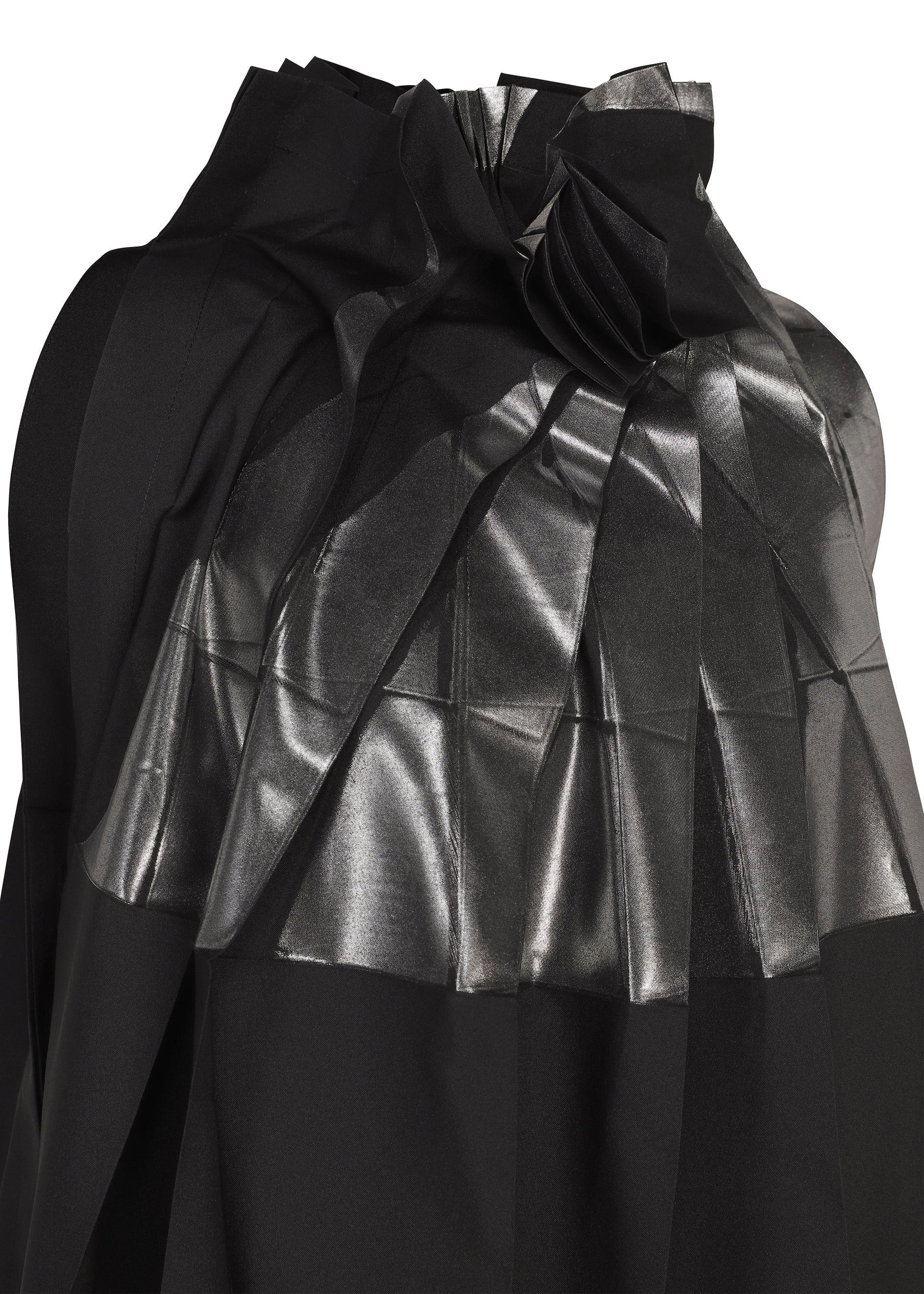 Zoomed view A close-up of No.3-2 by 132 5. ISSEY MIYAKE, a black recycled polyester dress featuring shiny, metallic-textured pleats and overlapping folds that create a geometric pattern across the fabric reminiscent of foil processing.