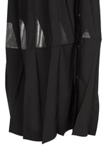 No.3-2 by 132 5. ISSEY MIYAKE is a black pleated skirt with overlapping folds, accented by shiny silver geometric patches and side buttons.