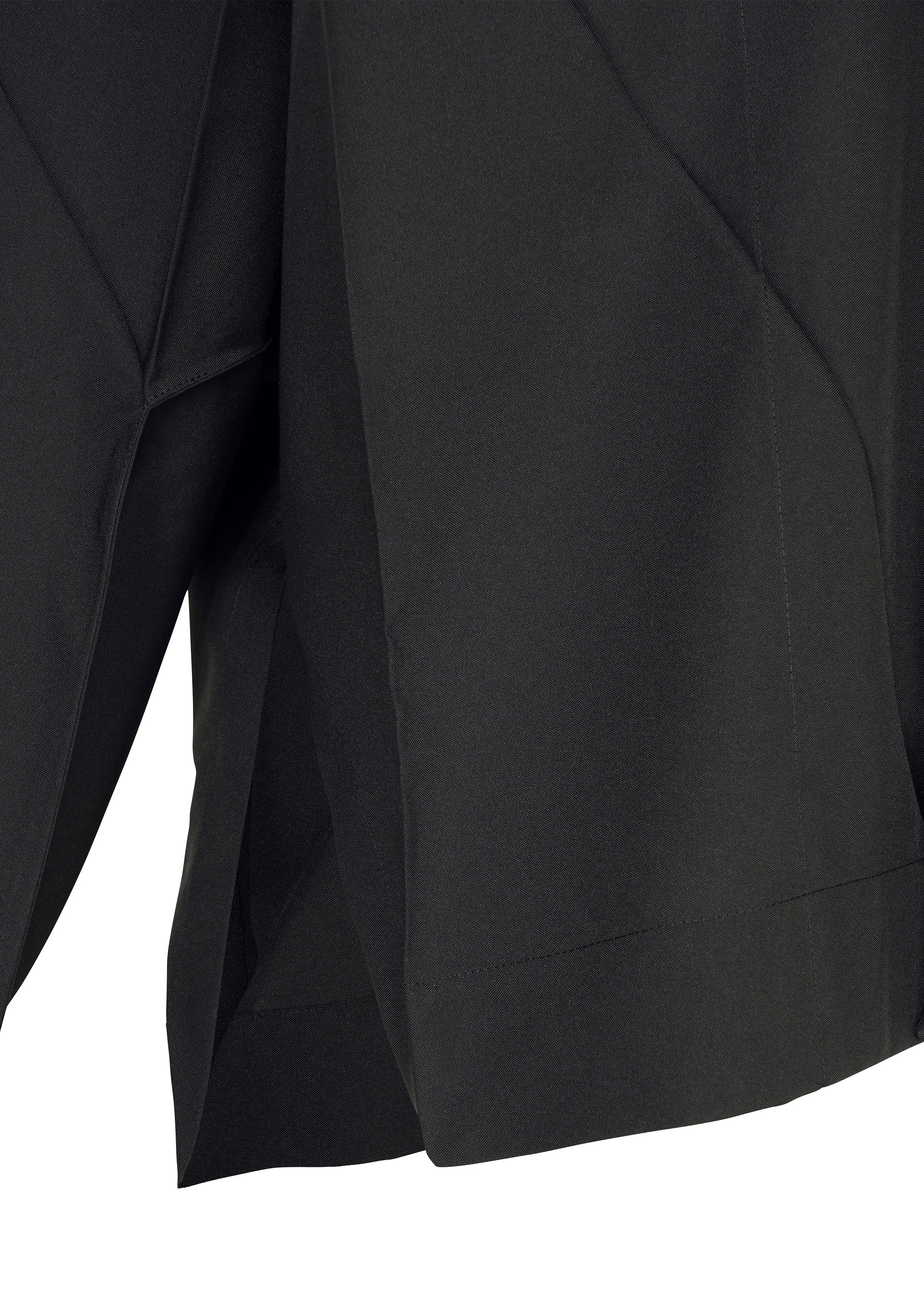 Zoomed view Close-up of F-SH-2 by 132 5. ISSEY MIYAKE, featuring black fabric with angular, overlapping folds and a hemmed edge, reminiscent of the brand’s signature folding techniques. The lighting emphasizes the texture and sculptural structure of the material, suggesting a garment such as a skirt or pair of shorts.