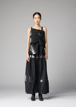 A woman faces forward in the No.1-1 set by 132 5. ISSEY MIYAKE, featuring a black recycled polyester top and wide-leg pants with pyramid folds and metallic accents, styled with black ankle boots against a plain gray background.