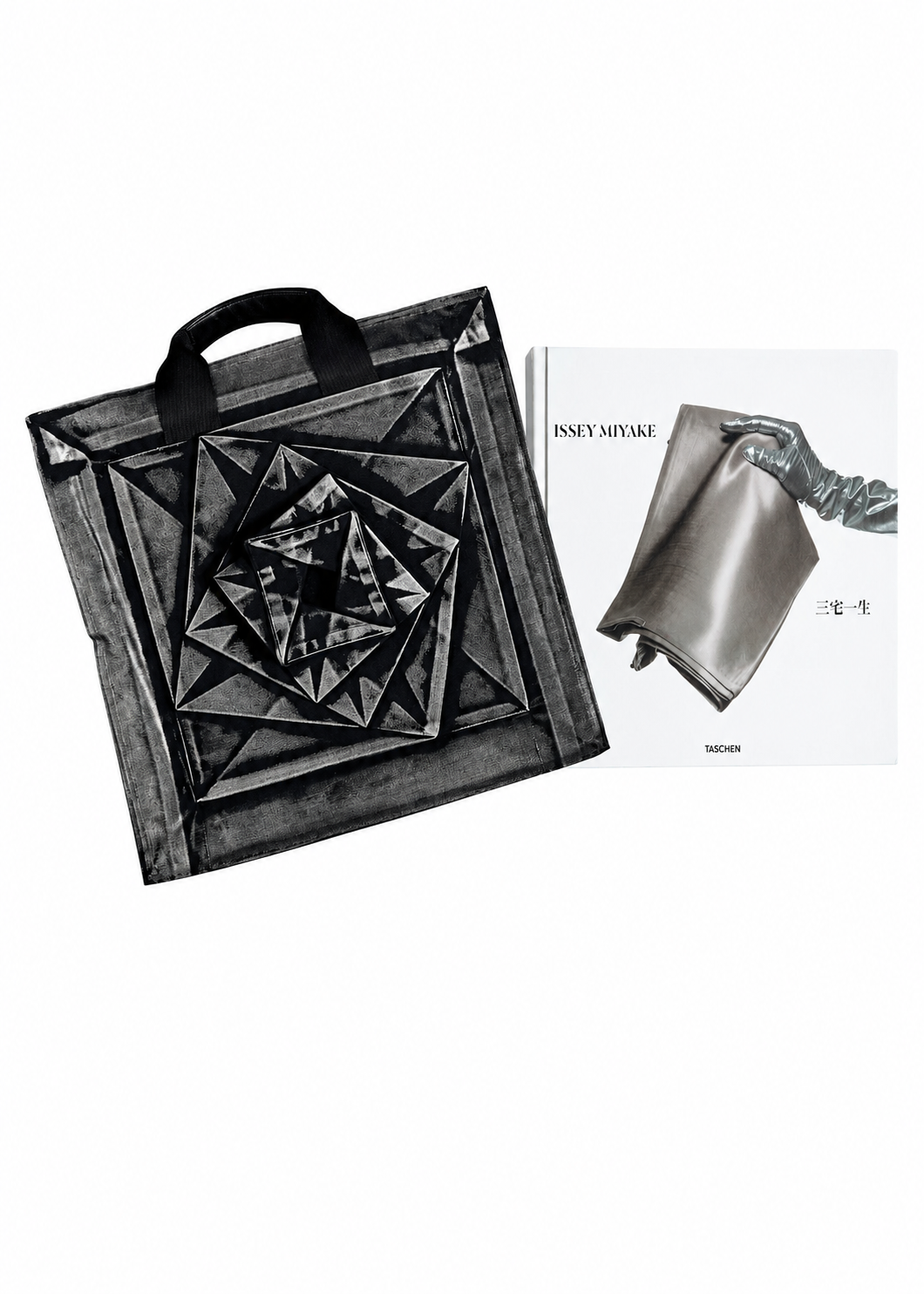 A black geometric tote bag with layered square motifs is showcased beside the ISSEY MIYAKE (Limited Collectors Edition) book by ISSEY MIYAKE BOOKS, whose cover features a metallic, sculptural bag—an eye-catching tribute to Issey Miyake’s avant-garde design philosophy. view 2 of 17