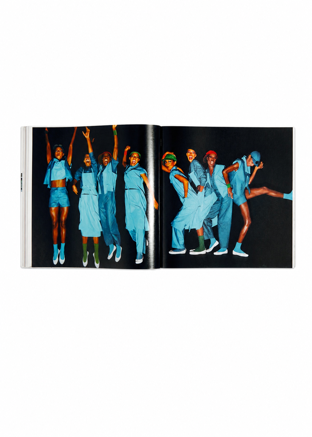 Zoomed view An open copy of the ISSEY MIYAKE (Limited Collectors Edition) by ISSEY MIYAKE BOOKS showcases seven individuals dressed in blue, energetically posing against a black backdrop—some leaping mid-air while others strike playful stances. Reflecting Issey Miyake’s design philosophy, the image conveys movement and innovation, embodying the essence of this unique Collector’s Edition.