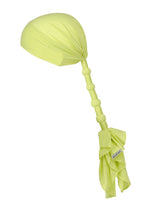 The ISSEY MIYAKE WRAPPED PONYTAIL is a light green jersey headscarf or bonnet with a long, gathered, knotted tail for a ponytail look and a small white tag near the end.