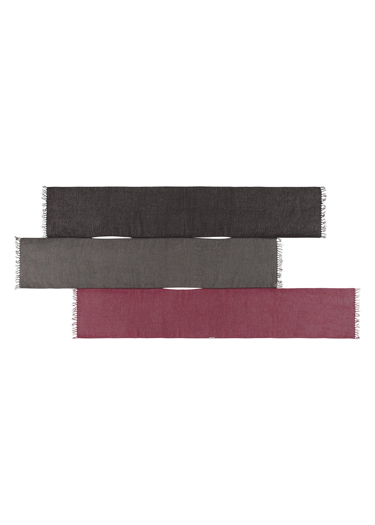 Three SLITS STOLE scarves by ISSEY MIYAKE, in dark gray, medium gray, and burgundy, are laid flat and stacked vertically. Each cotton stole has short fringe on the short edges and offers versatile styling options. view 4 of 7