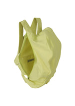 The ISSEY MIYAKE PAPER BALLOON 2 is a light yellow backpack with a curved, crinkled texture inspired by Japanese Washi paper, two wide shoulder straps, and an inner label, displayed against a white background.
