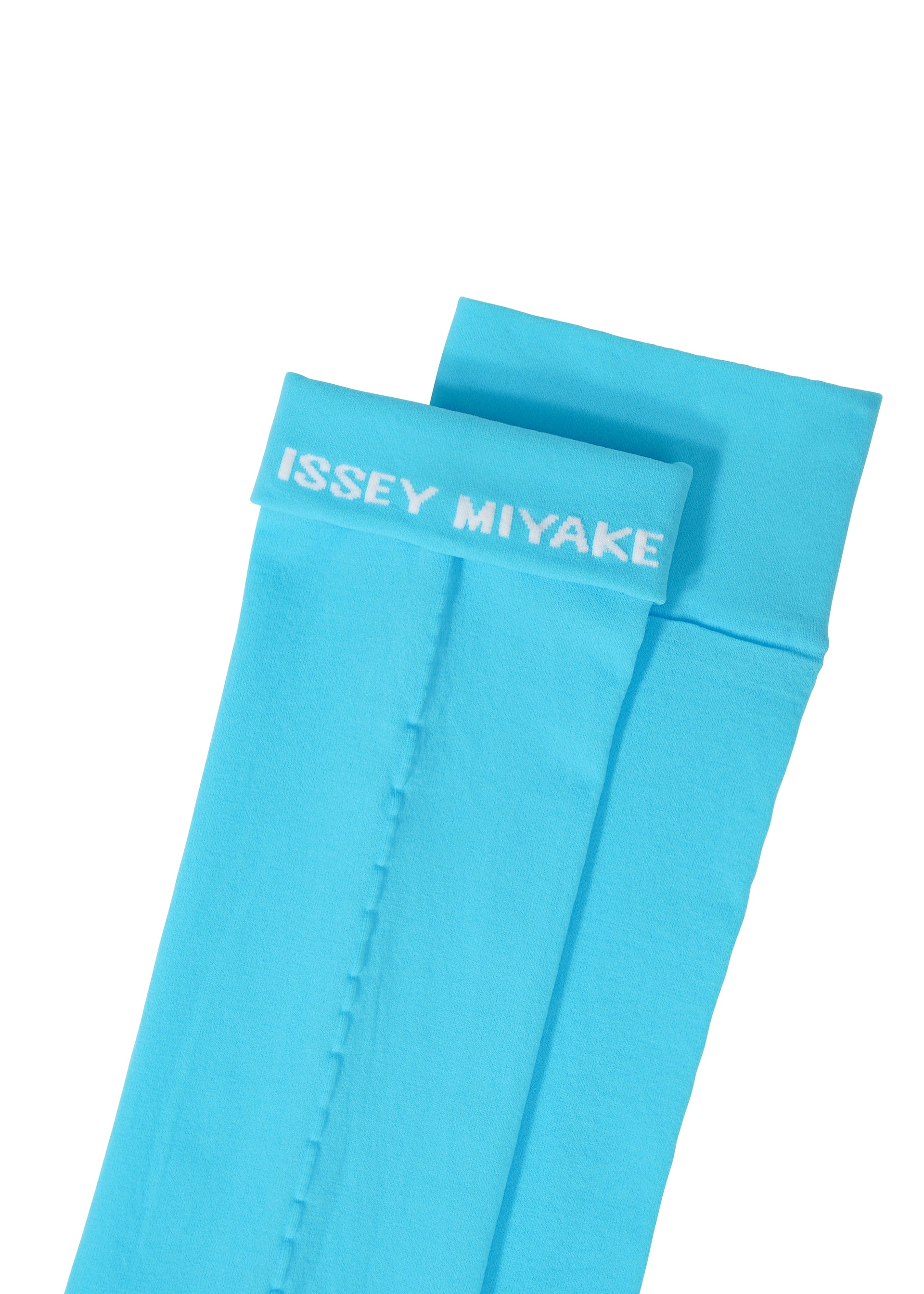 Zoomed view Two vibrant blue SHEER SOCKS by ISSEY MIYAKE feature a bold white logo in all-caps near the top cuff of one sock. The socks are displayed flat and slightly overlapping.