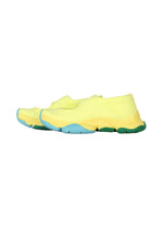The ISSEY MIYAKE KARST FINCH sneakers feature a vibrant yellow upper and a chunky sole in blue, green, and yellow—ideal for anyone seeking colorful and standout style. Displayed on a white background.