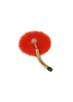 The ISSEY MIYAKE ENGINEERED FLOWER ACC is a red, round accessory with a furry texture, brass curved handle, green tip, and transparent suction cup, set against a plain white background.