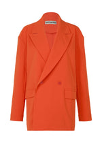 The ISSEY MIYAKE LOOPED jacket features a bright orange double-breasted design with wide lapels, flap pockets, two front buttons, and straight long sleeves in stretch fabric for comfort. Brand label visible inside the collar. - MACAW RED （no.28）