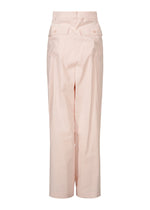 The GENERIC WEAR pants by ISSEY MIYAKE feature a light pink high-waisted design, wide legs, and two flap pockets with buttons near the waistband—a playful style perfect for making a statement.