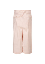 The ISSEY MIYAKE GENERIC WEAR shorts are light pink, high-waisted with a straight, loose fit, belt loops, and two back pockets with buttoned flaps. Made from lightweight fabric for warm weather versatility. Shown on a white background.
