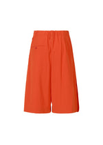 The LOOPED shorts by ISSEY MIYAKE are bright orange, knee-length, and made from stretch fabric with a playful design, elastic waistband, and a single back pocket. Shown on a plain white background.