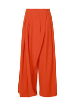 The LOOPED culotte pants by ISSEY MIYAKE feature a bright orange hue, high waist, distinctive belt loops, and overlapping draped front panels, shown against a plain white background. - MACAW RED （no.28）