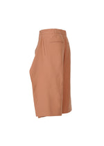 Side view of ISSEY MIYAKE FLUTTERING PANTS—light brown, lightweight shorts with an elastic waistband and two rear welt pockets, made from durable double-woven fabric—displayed on a plain white background.