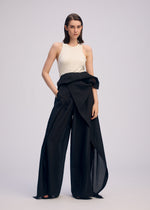 A woman with straight, shoulder-length hair and a neutral expression wears the ISSEY MIYAKE ALL SQUARES sleeveless white top and black high-waisted, asymmetrical draped pants against a plain background.
