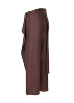 The PLEATED ON PLEATS skirt or pants by ISSEY MIYAKE features brown pleats and an asymmetrical, draped overlay, shown from the side against a white background.