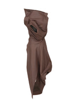 The PEU FORM³ by ISSEY MIYAKE, from the Autumn Winter 2025/26 collection, is a brown abstract sculptural garment in artificial leather with draped and folded fabric, covering most of the body and head with an opening for one eye.