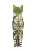 The ISSEY MIYAKE URBAN JUNGLE PLEATS is a sleeveless, knee-length fitted dress with ribbed texture, round neckline, and a vibrant palm plant and floral print set against a light background.